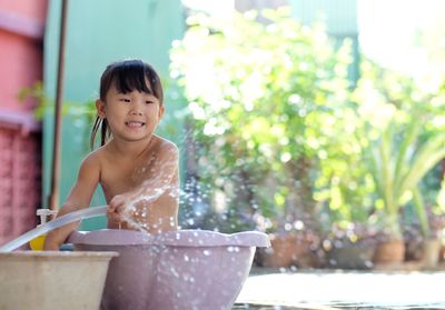 Portrait of smiling girl sitting outdoors