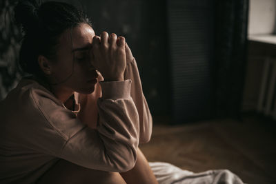 Rear view of woman sitting at home