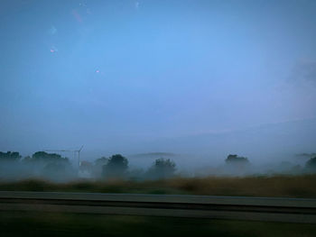 Scenic view of field against sky during foggy weather