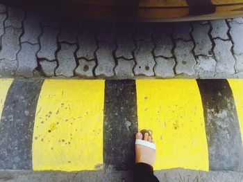 Woman standing against yellow wall