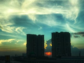 View of cityscape against cloudy sky