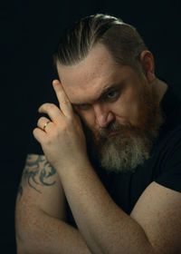 Portrait of young man against black background