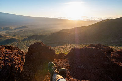 Low section of person on mountain against sky