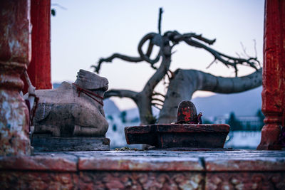 Close-up of rusty statue against sky