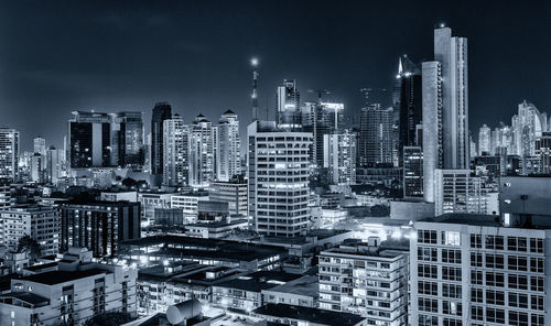 Illuminated cityscape against sky at night