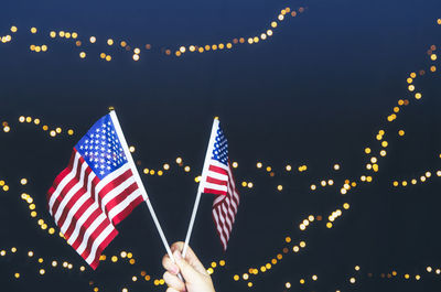 Low angle view of illuminated flags against sky at night