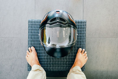 Low section of person standing by helmet