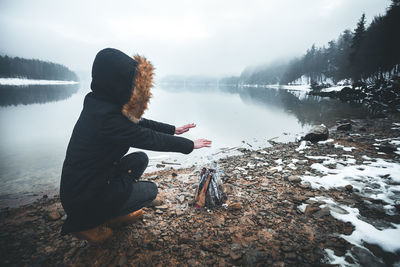 Rear view of woman in lake during winter