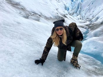 Portrait of woman crouching on glacier 