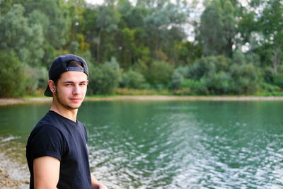 Portrait of young man against lake