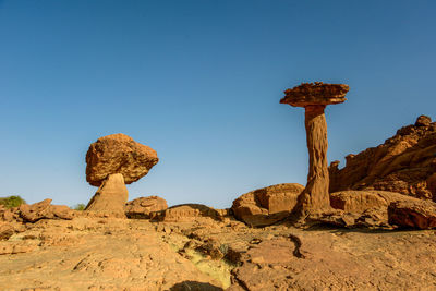 Rock formations against clear blue sky