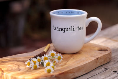 Close-up of white daisies with herbal tea on table