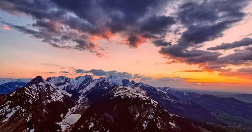 Scenic view of snowcapped mountains against sky at sunset