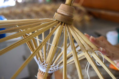Craftsperson making paper umbrella with wood at workshop