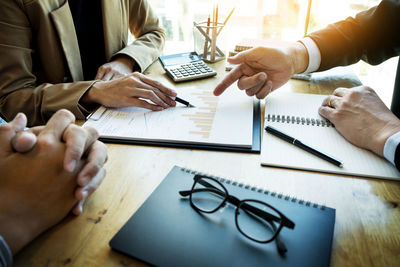 Close-up of people working on table