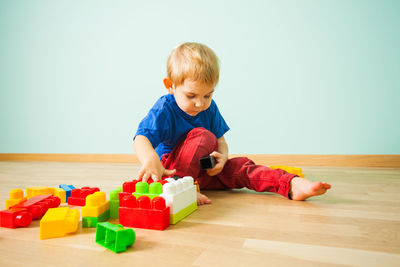 Cute boy playing with toy on floor