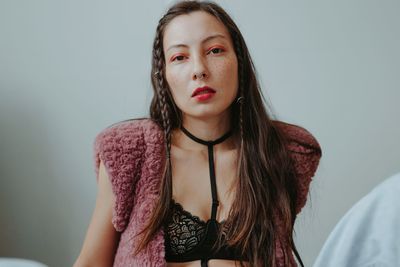 Sad woman with pink makeup at home