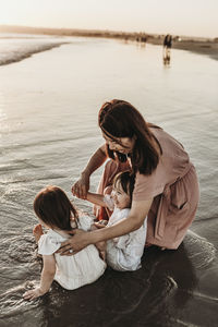 Rear view of mother and daughter at beach