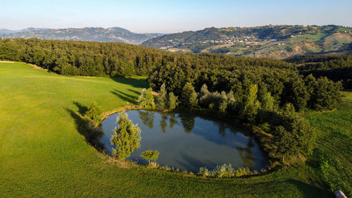 Scenic aerial view from the drone of a little lake with trees and hills