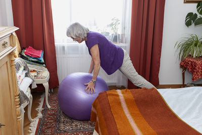 Senior woman exercising with fitness ball