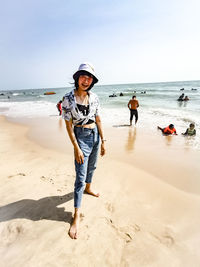 Full length of boys on beach against sky