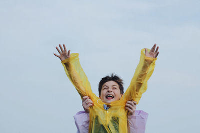 Low angle view of young woman against sky