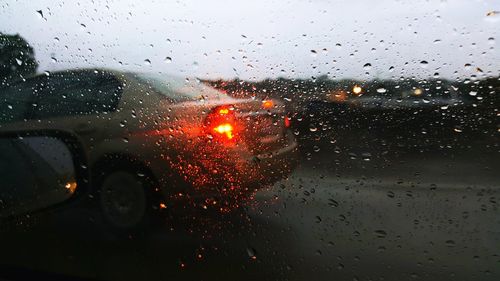 Raindrops on windshield seen through wet window