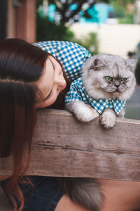 Young woman with cat by fence