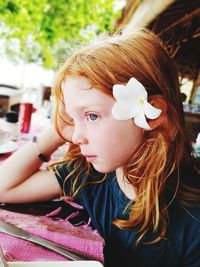 Close-up of girl looking away while sitting outdoors