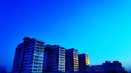 Low angle view of buildings against blue sky