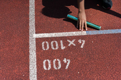 Low section of woman holding equipment on running track