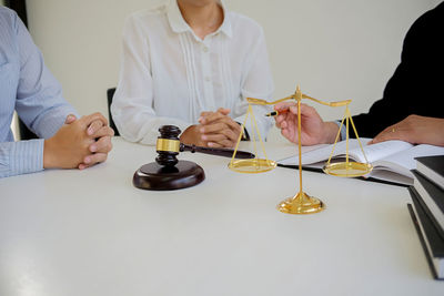 Midsection of lawyer discussing with man and woman