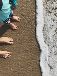 Low section of family standing at beach