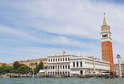Grand canal by san marco campanile tower against cloudy sky
