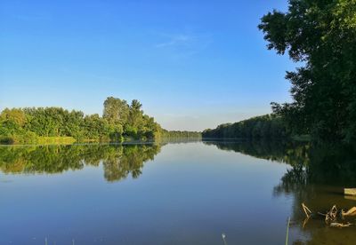 Scenic view of lake against clear blue sky