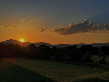 Scenic view of field against sky during sunset