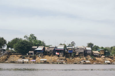 Houses by sea against sky