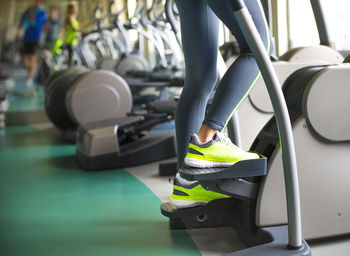 Low section of woman standing on exercise equipment