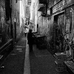 Rear view of people walking on narrow street