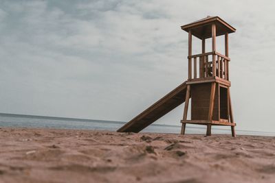 Lifeguard hut on beach against sky