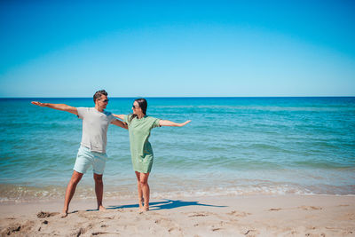 Rear view of woman standing at beach