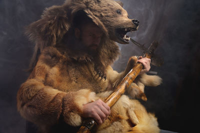 Man with a bear's head, clothes made from the skin of an animal. warrior cosplay costume