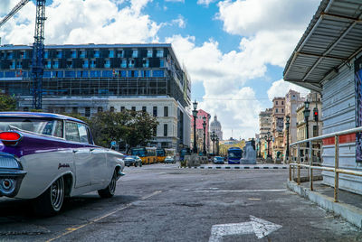 Vehicles on road against buildings in city