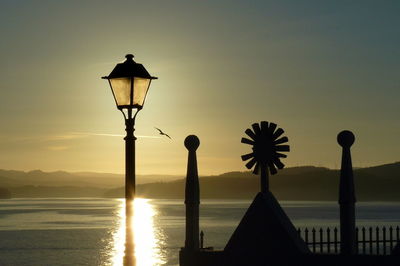 Silhouette street light against sky during sunset