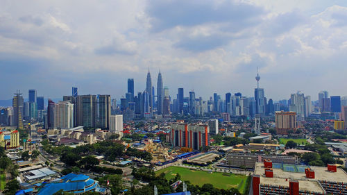 View of cityscape against cloudy sky