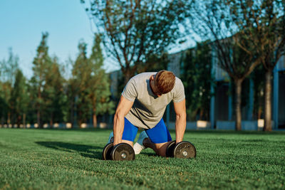 Man exercising with dumbbells at park