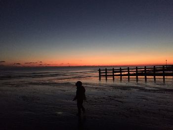 Pier on sea at sunset