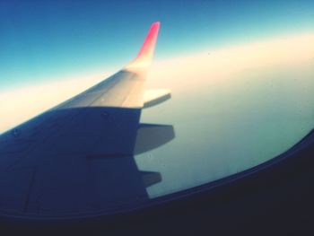 Cropped image of airplane flying over clouds