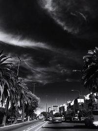 Cars on road against sky in city