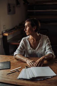 Female artist sitting at table in studio